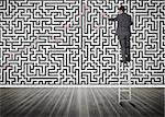 Businessman standing on a ladder solving maze puzzle in an empty room