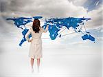 Businesswoman touching at a world map with blue sky on the background