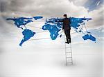 Businessman standing on a ladder drawing a world map with blue sky on the background