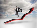 Businessman jumping over a red arrow pointing up with blue sky on the background