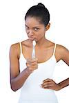 Woman pointing at camera with her toothbrush on white background