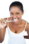Smiling woman brushing her teeth on white background