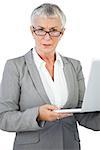 Businesswoman with glasses holding her laptop on white background