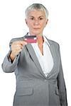 Serious businesswoman showing her credit card on white background