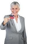 Smiling businesswoman showing her credit card on white background