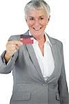 Happy businesswoman showing her credit card on white background