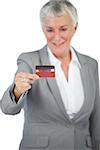 Cheerful businesswoman showing her credit card on white background