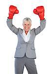 Businesswoman wearing boxing gloves and raising her arms on white background