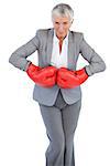 Businesswoman wearing boxing gloves on white background