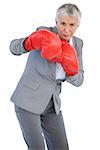 Businesswoman boxing with her boxing gloves on white background