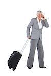 Smiling businesswoman with her luggage and calling someone on white background