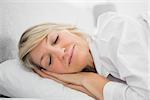 Blonde woman sleeping peacefully at home in bed