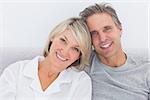 Cheerful couple in bed smiling at camera