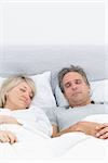 Couple sleeping soundly in their bed at home in bedroom