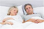 Couple sleeping peacefully in their bed at home in bedroom