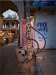 Cafe sign and street view at nightfall in old quarter of Binda, India