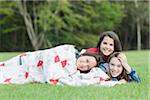 Portrait of Girls Lying under Blanket Outdoors, USA