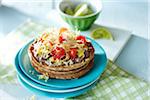 Open Faced Vegetarian Sandwich with Black Beans, Tomatoes, Lettuce, and Corn, with Lime Wedges in the Background