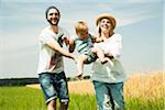 Parents Swinging Baby Daughter by Agricultural Field, Mannheim, Baden-Wurttemberg, Germany