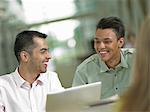 Young student looking at laptop with mid adult tutor, smiling