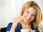 Mid adult woman holding cup and smiling, portrait