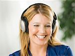 Mid adult woman wearing headphones and smiling