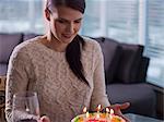 Young woman looking at birthday cake