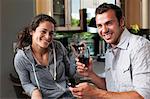 Young couple enjoying wine at home, portrait