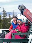 Mature man and young woman relaxing together in ski resort