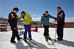 Mature man and young woman with ski instructors on ski slope