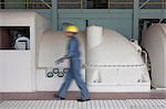 Mature construction worker walking through power station, blurred motion