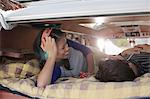 Couple lying together in the back of camper van, smiling