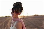 Young woman wearing sunglasses in desert, portrait