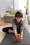 Mid adult woman doing yoga at home