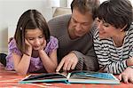 Daughter looking at picture book with parents