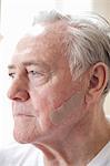 Portrait of senior man with adhesive plaster on cheek