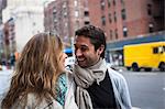 Smiling couple walking down city street