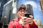 Portrait of woman in city looking at smartphone