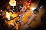 Man wearing hat and sunglasses playing guitar