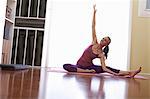 Woman sitting on floor with arm raised