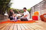 Family sitting on rug on patio