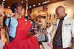 Young woman showing man red vintage dress