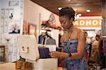 Young woman looking through box of items in vintage shop