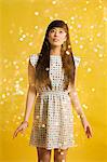 Portrait of young woman wearing spotted dress with glitter