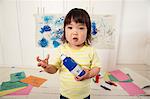 Female toddler holding paint bottle