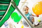 Young girl crouching with balloons