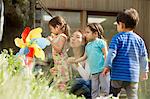 Mother and three children with toy windmill in garden