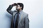 Studio portrait of businessman with hand shading eyes