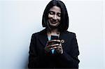 Studio portrait of businesswoman looking at cellphone