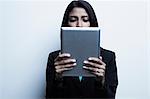 Studio portrait of businesswoman holding digital tablet